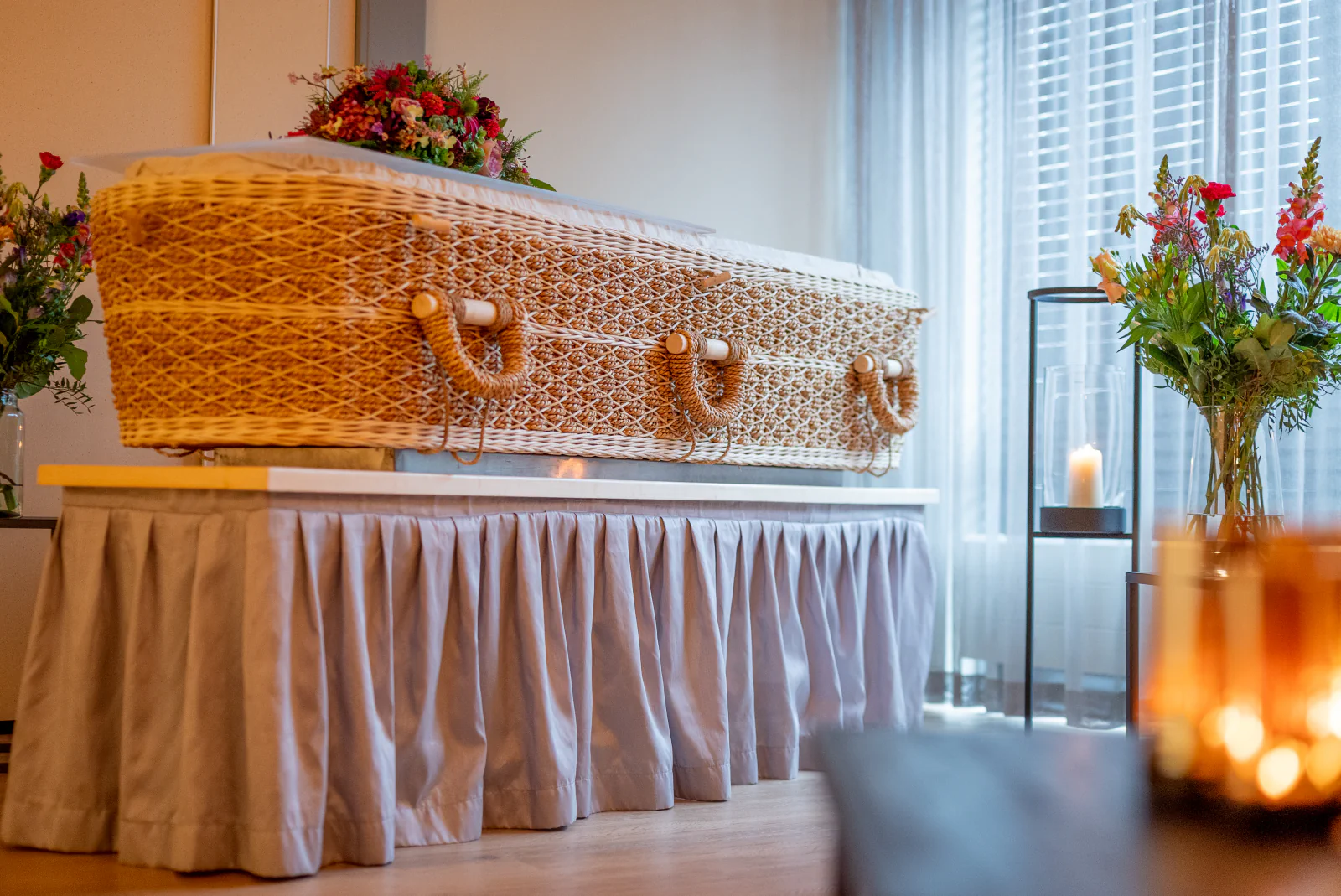 Uitvaartkist met bloemen in de opbaarkamer van Ontmoetingscentrum De Jonge